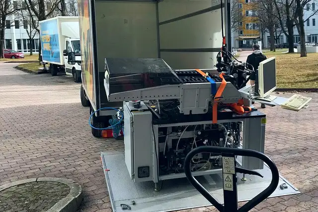 Firmenumzug, eine Maschine wird mit dem Hubwagen verladen